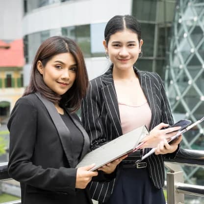 close-up-two-business-woman-looking-with-paper-document-together-while-walking-office-business-people-concept